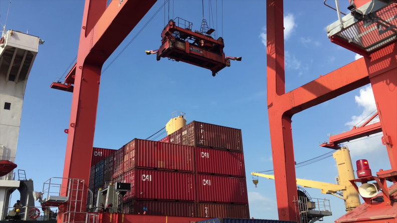 Shipped.com - Loading shipping containers onto a ship at the Cambodian port of Sihanoukville