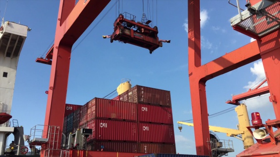 Shipped.com - Loading shipping containers onto a ship at the Cambodian port of Sihanoukville